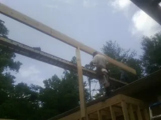 Carpenter setting a ridge beam over a new addition frame — Ice Dam Removal by Roofing Brothers in South Pekin