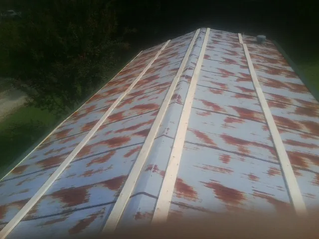 Rusted metal roof panels with new wood purlins before replacement — Storm Damage Roof Repair in South Pekin by Roofing Brothers
