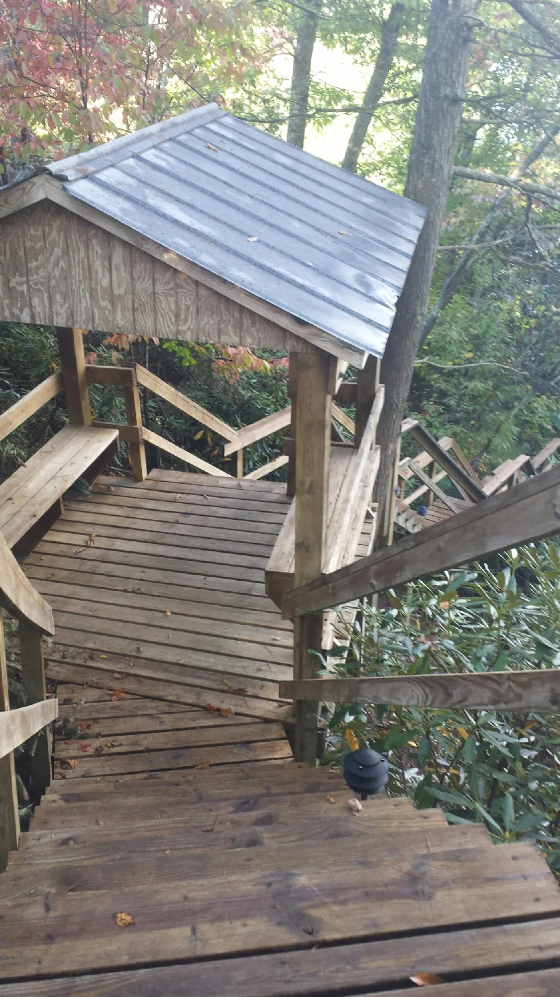 Metal roofed shelter over wooden steps on a wooded walkway — Skylight Repair & Installation work by our crew in South Pekin