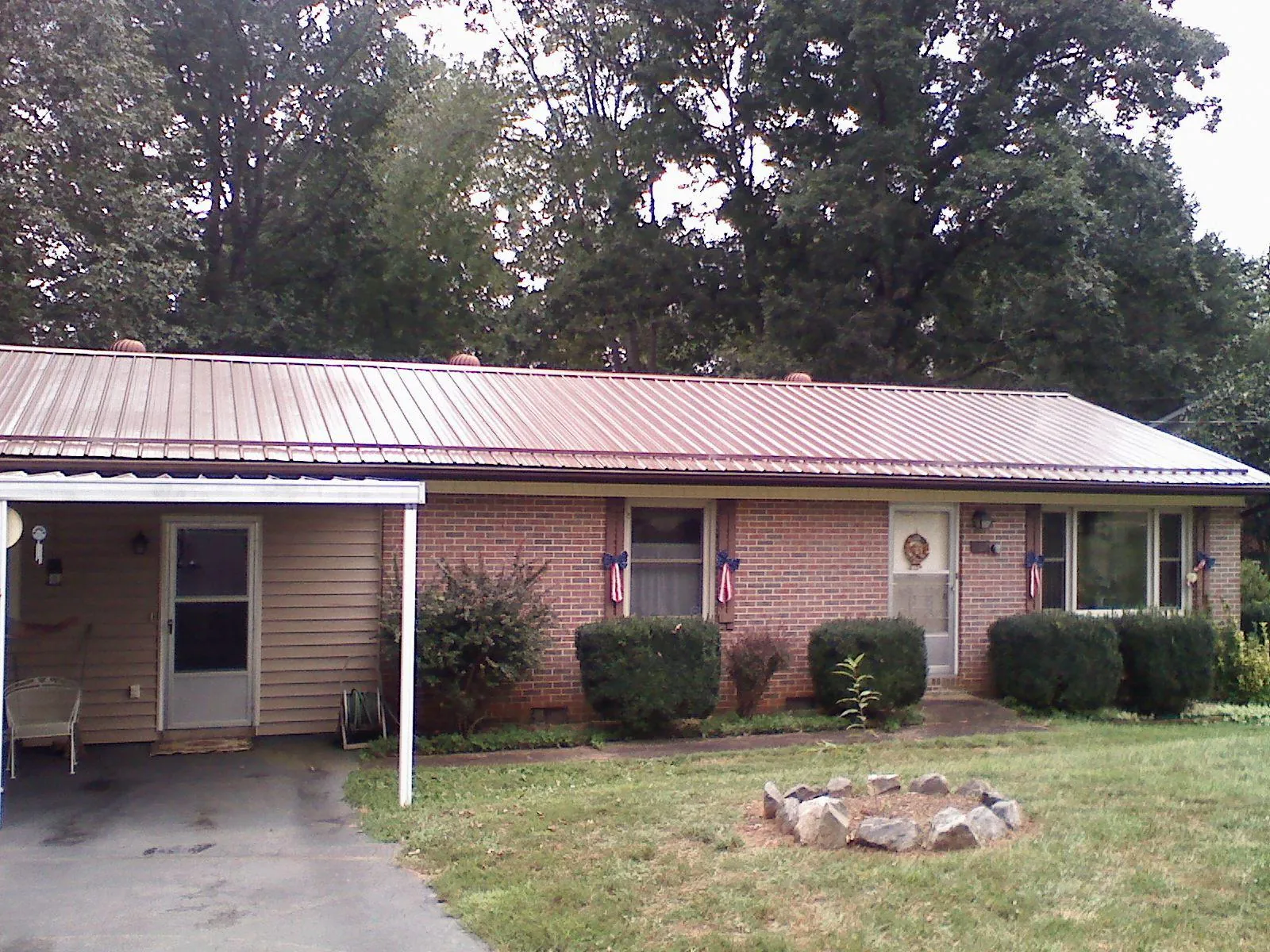 Bronze metal roof and carport on a brick ranch home — Roof Repair work by our crew in South Pekin